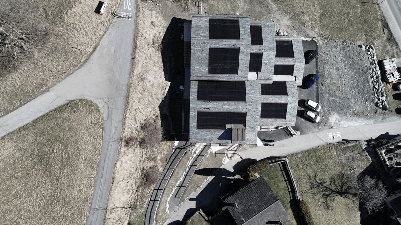 I tetti del Cotterg visti dall'alto: copertura in pietra grigia e i campi fotovoltaici dell'edificio Minergie.