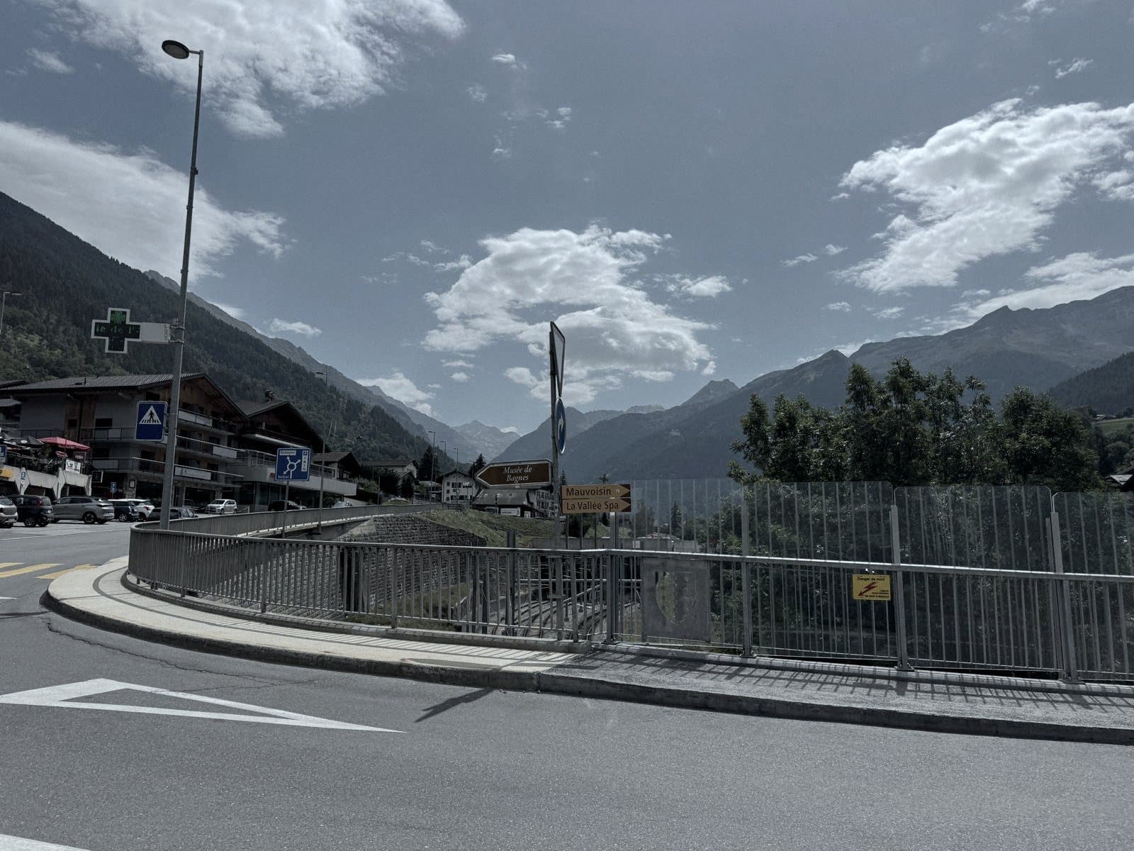 L'entrée du village : le pont sur la tranchée du train, les commerces et la pharmacie au pied des immeubles.